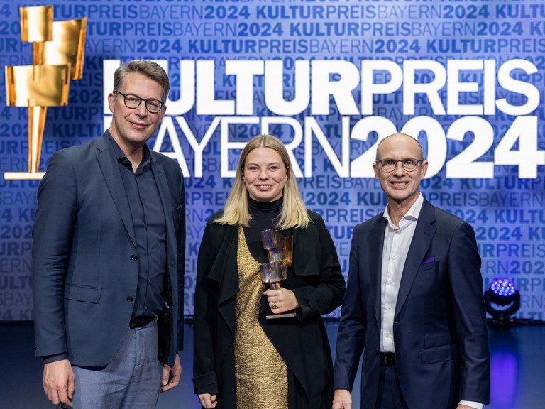 Preistr&auml;gerin Dr. Johanna Zimmermann steht neben Minister Markus Blume (l.) und Bayernwerk-Chef Dr. Egon Leo Westphal (r.).