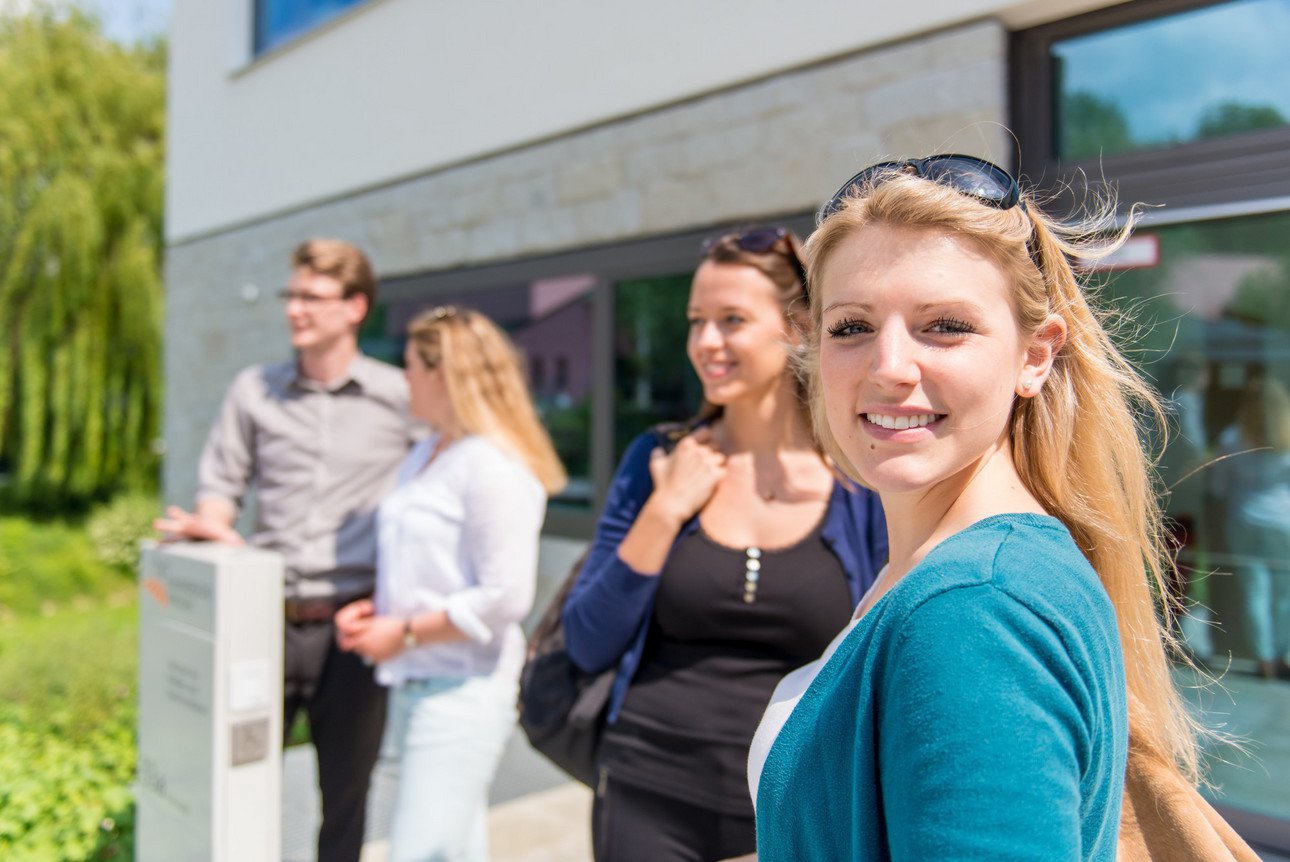 Studierende vor einem Universit&auml;tsgeb&auml;ude