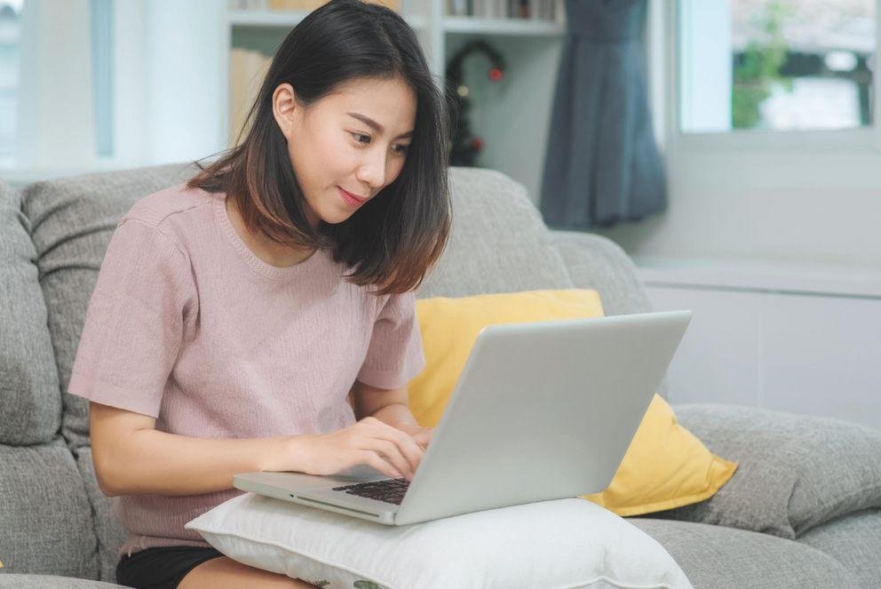 Studierende sitzt am Laptop und nimmt am Online-Spieleabend teil