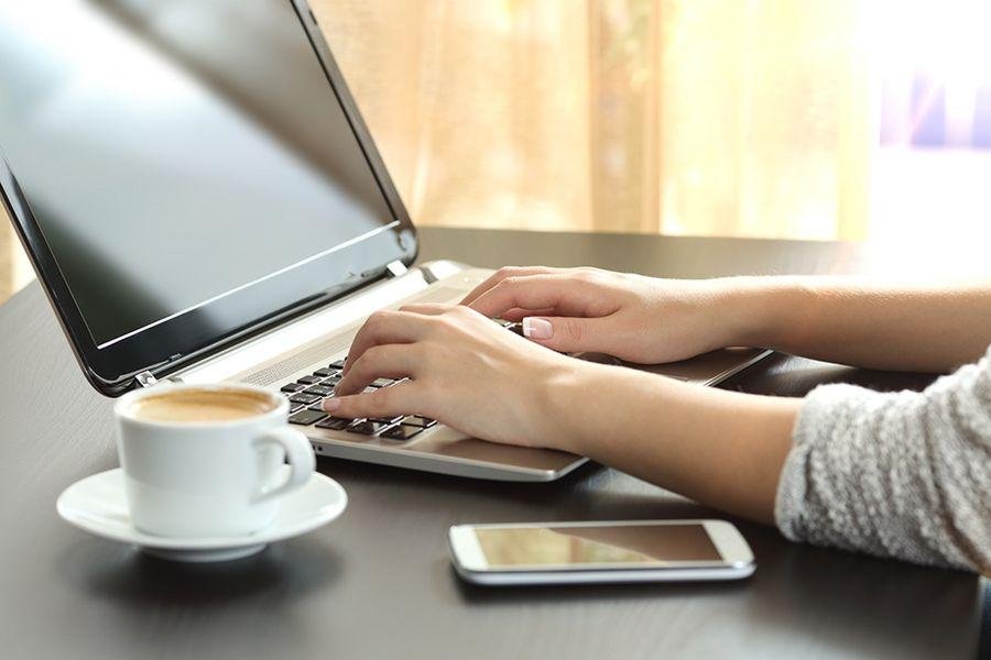 Studieninteressierter tippt auf Laptop-Tastatur zur Einschreibung.