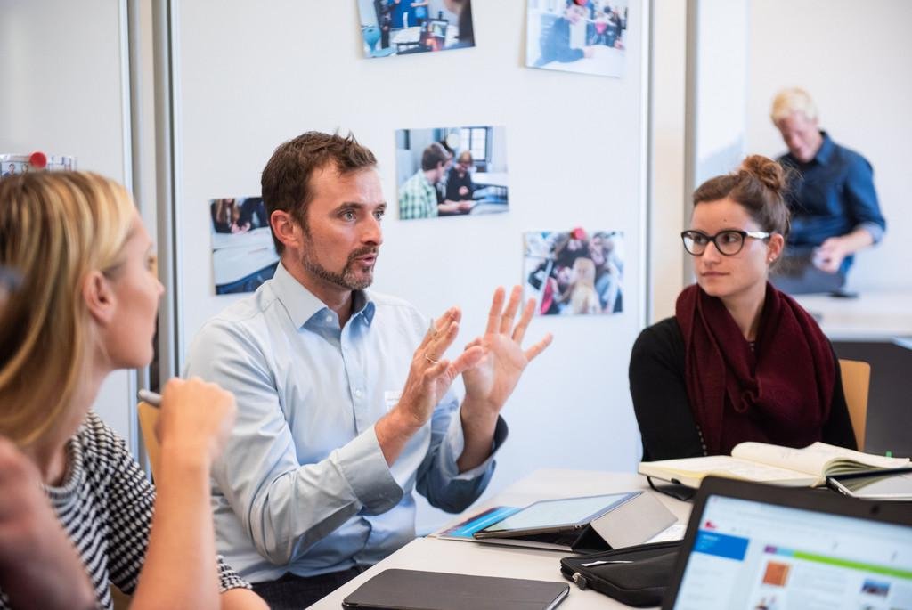 Personen sitzen am Tisch und diskutieren